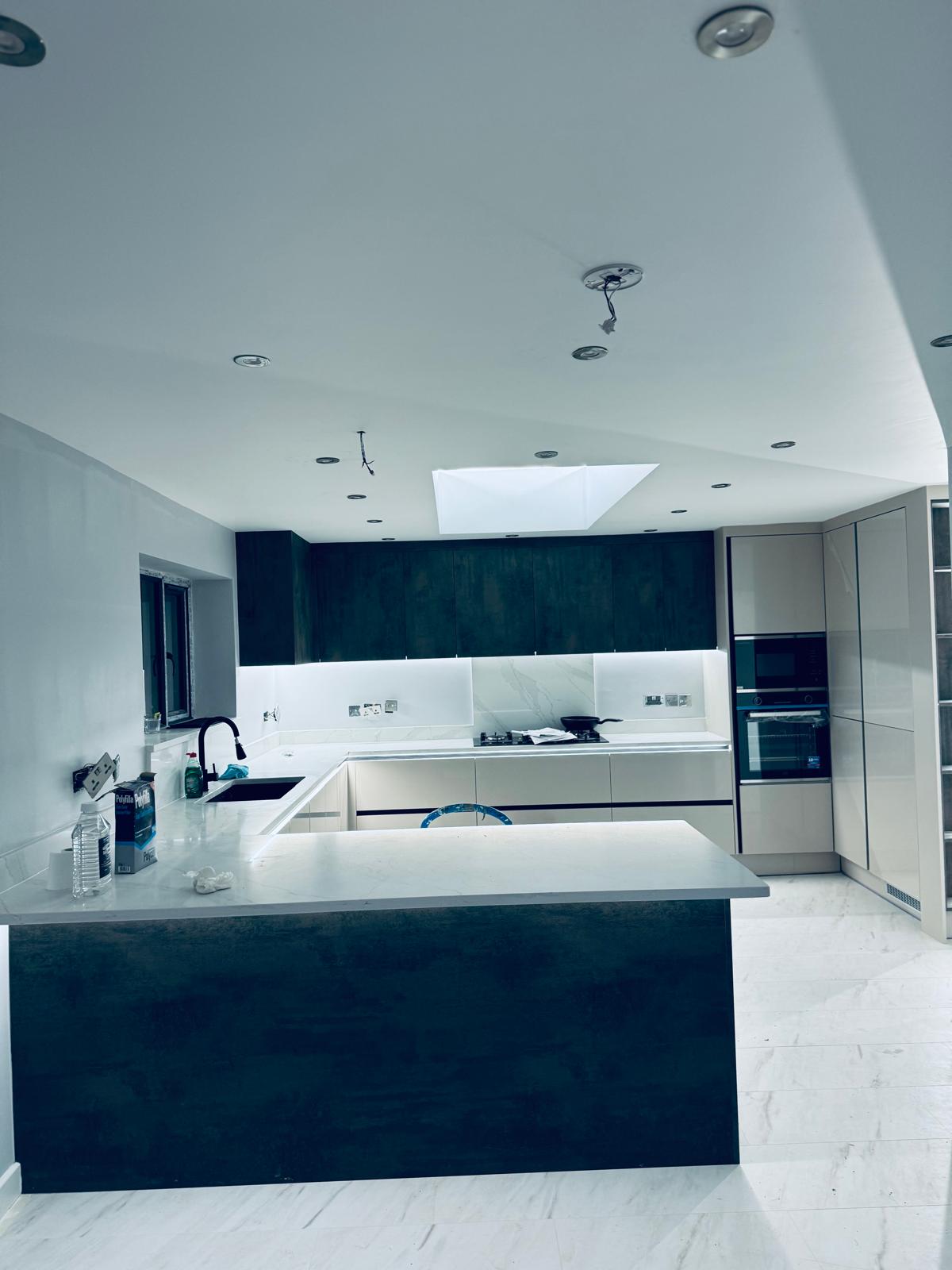 Finished handleless kitchen with marble worktops and skylight by SIB Construction in Slough