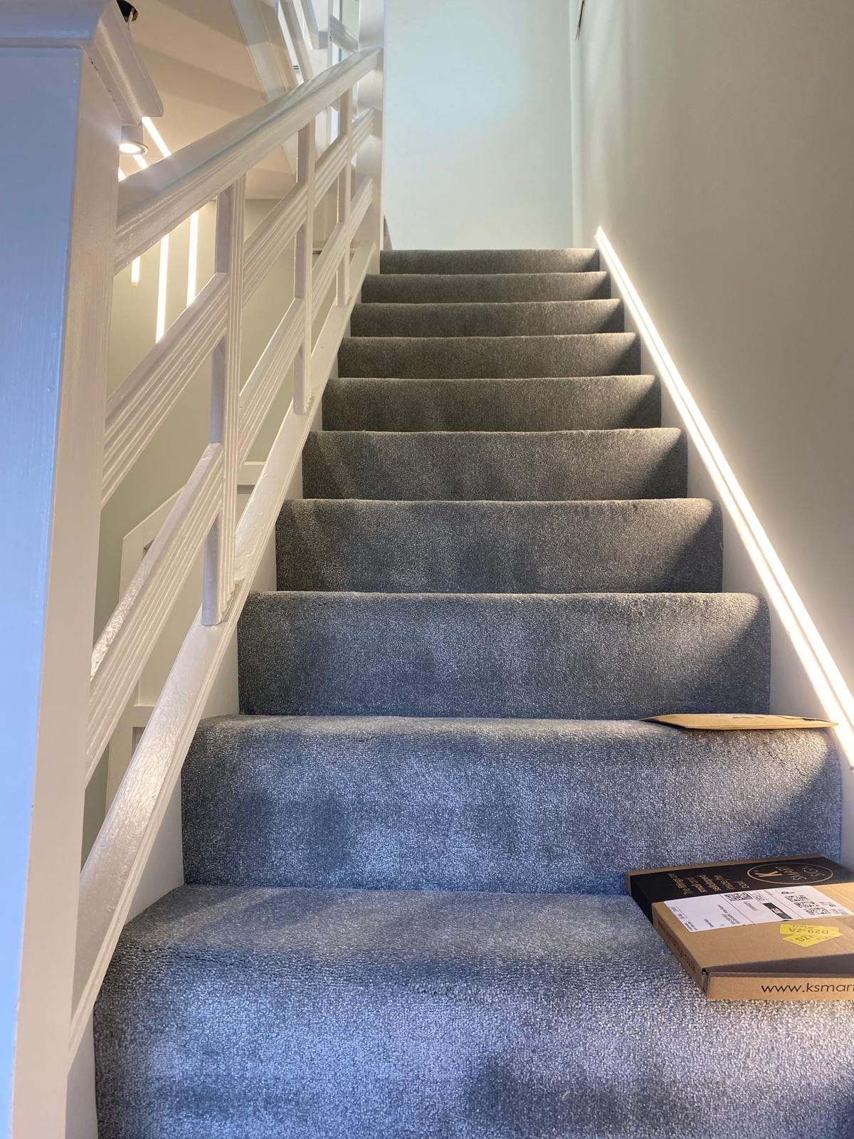 Finished hallway with grey stair carpet and white panelled balustrade by SIB Construction