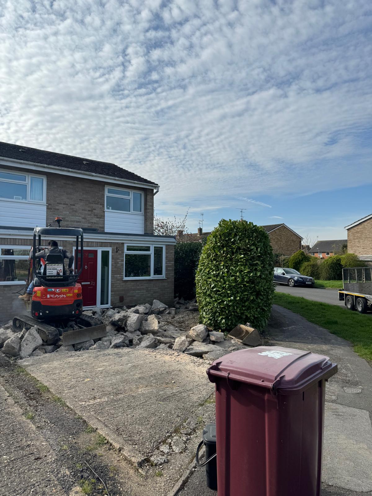 Old cracked concrete driveway being broken out by SIB Construction excavator in Reading